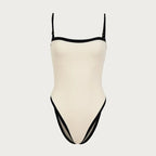 Beige swimsuit with black trim on a light gray background