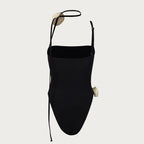 Black swimsuit with thin straps on a light gray background