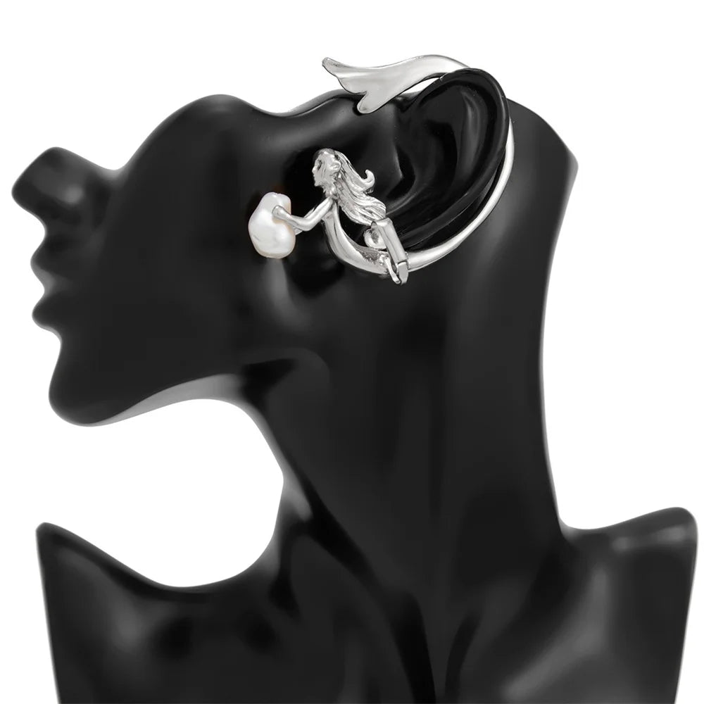 Silver earring on a black mannequin ear