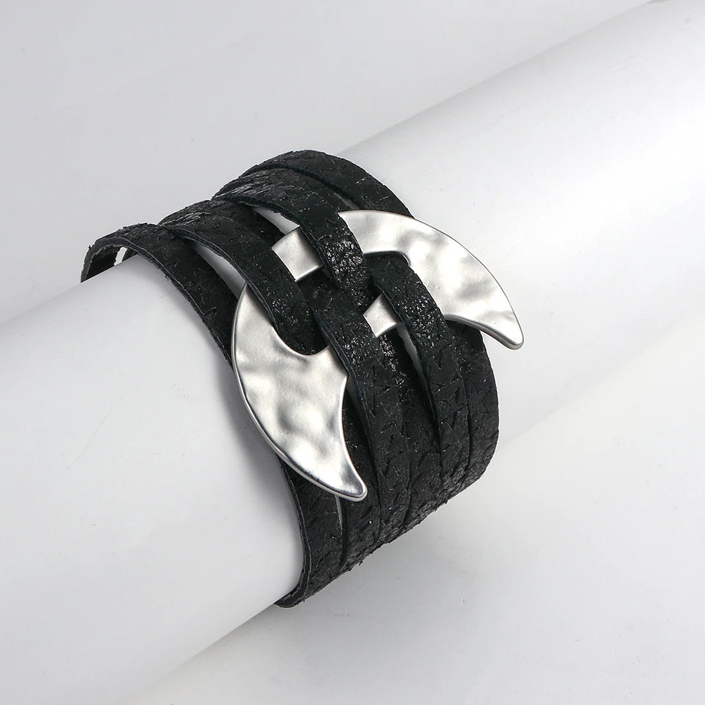 Black leather bracelet with silver leaf-like ends on a white arm