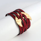 Red leather bracelet with gold claw-like ends on a white mannequin arm.