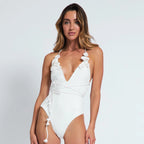 Woman wearing a white swimsuit against a plain background