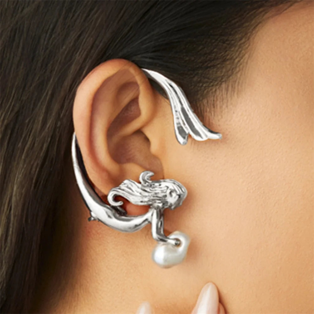 Silver ear cuff with pearl accent worn by a person