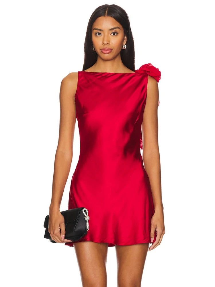 Woman wearing a red satin dress with a bow detail on a white background