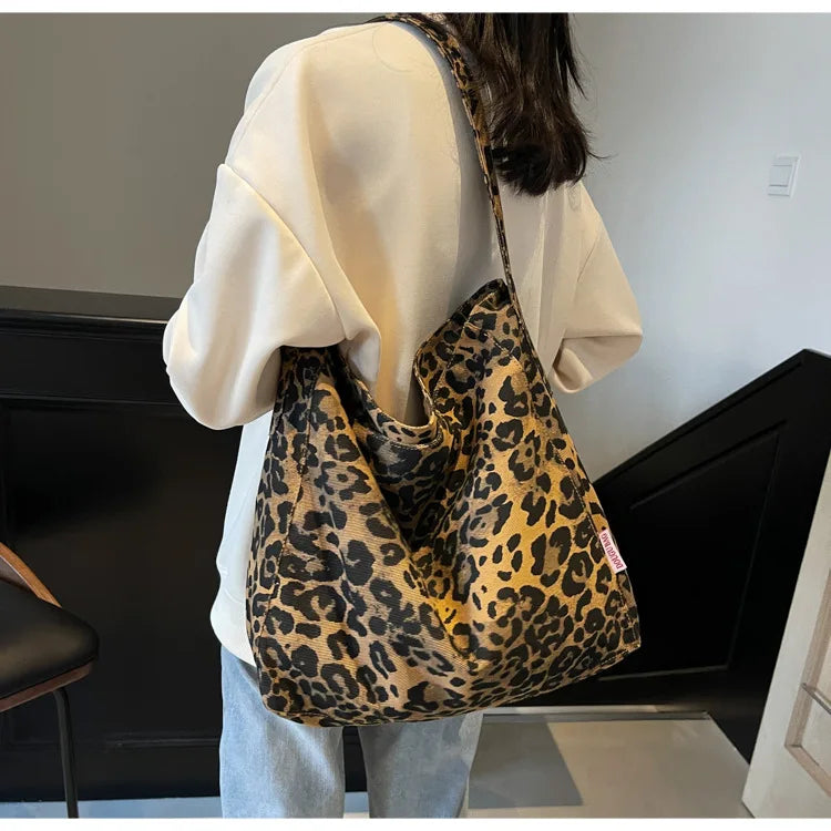 Person holding a leopard print bag indoors