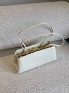 White handbag on a textured surface with a neutral background