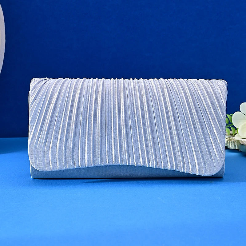 Silver pleated clutch bag on a blue background