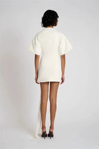 Person wearing a white dress with a plain background