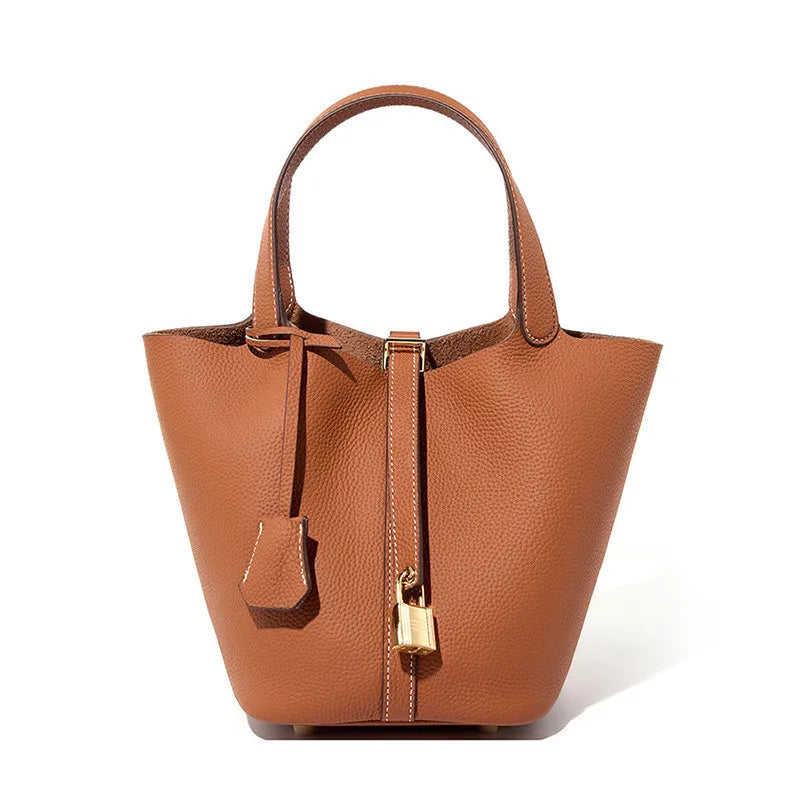 Brown leather handbag with a gold lock on a white background