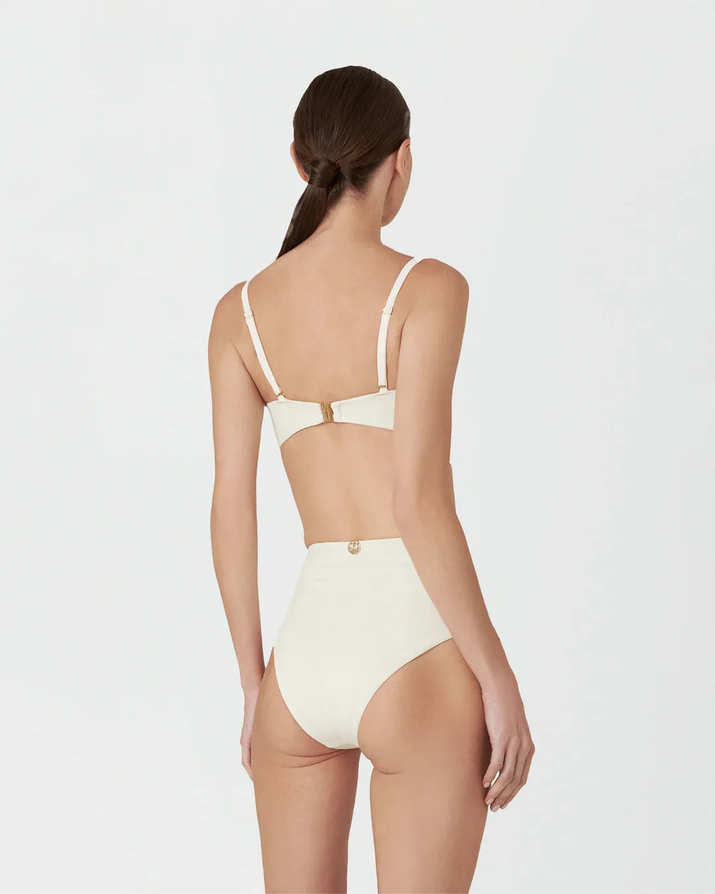 Woman wearing a beige bikini set on a white background