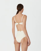 Woman wearing a beige bikini set on a white background