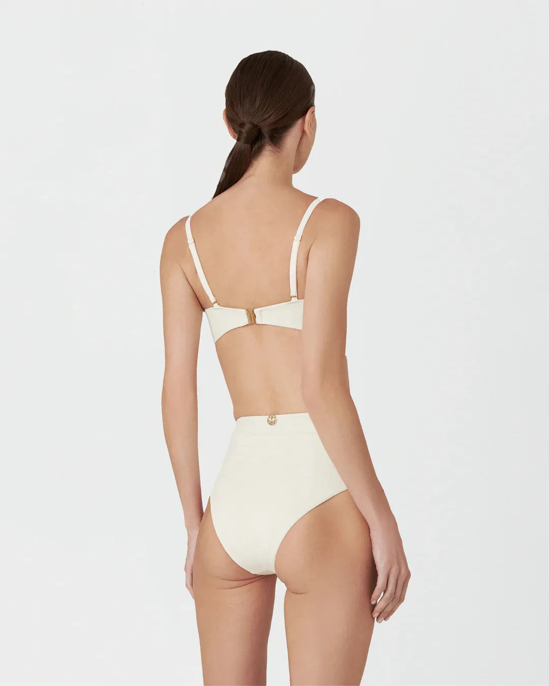 Woman wearing a beige bikini set on a white background