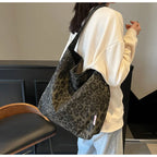 Person holding a leopard print bag in an indoor setting