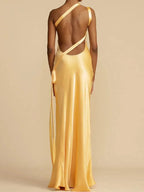Gold evening gown with open back on a plain background