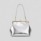 Silver handbag with a gold clasp on a light gray background