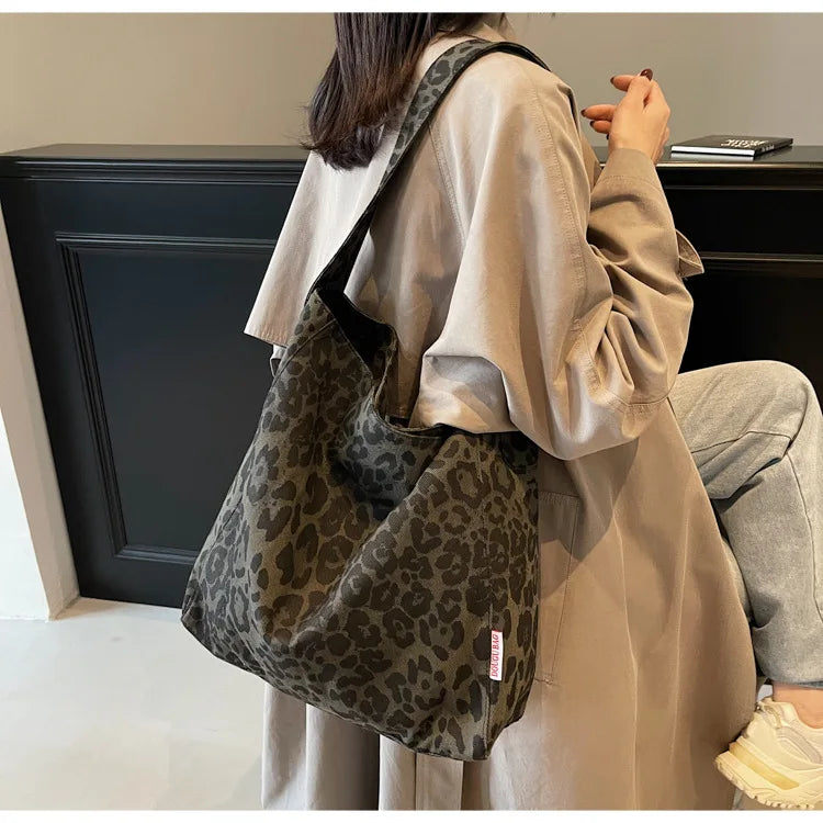 Person wearing a leopard print bag in an indoor setting