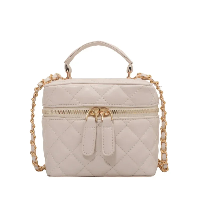 Beige quilted handbag with gold chain strap on a white background