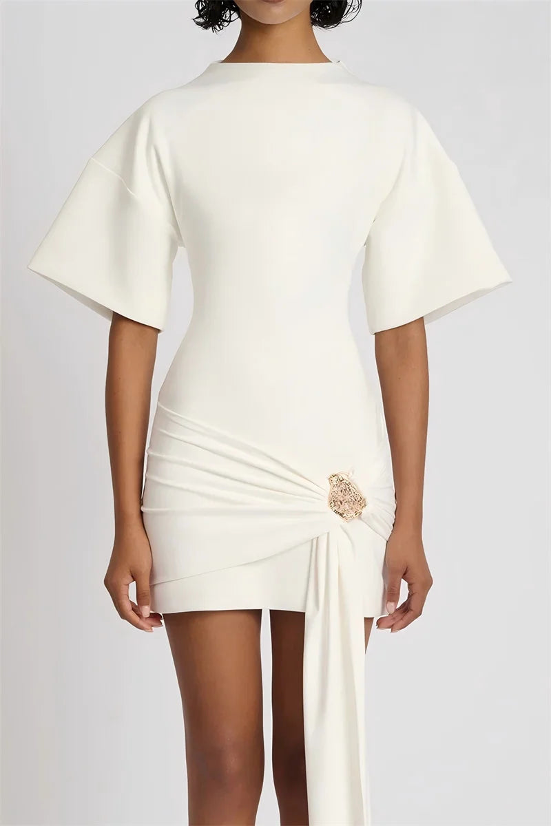 White dress with a decorative brooch on a plain background