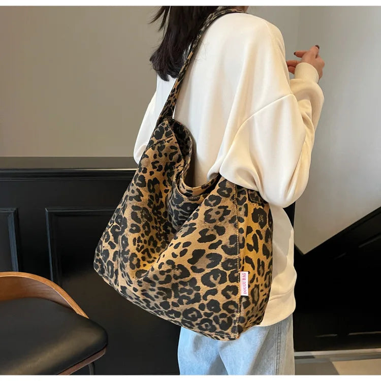 Person wearing a leopard print bag over their shoulder indoors.