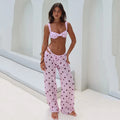 Woman wearing a pink polka dot bikini and matching pants in a bright setting