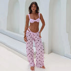 Woman wearing a pink polka dot bikini and matching pants in a bright setting