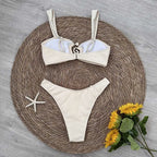 Beige bikini set on a woven mat with flowers and a starfish.