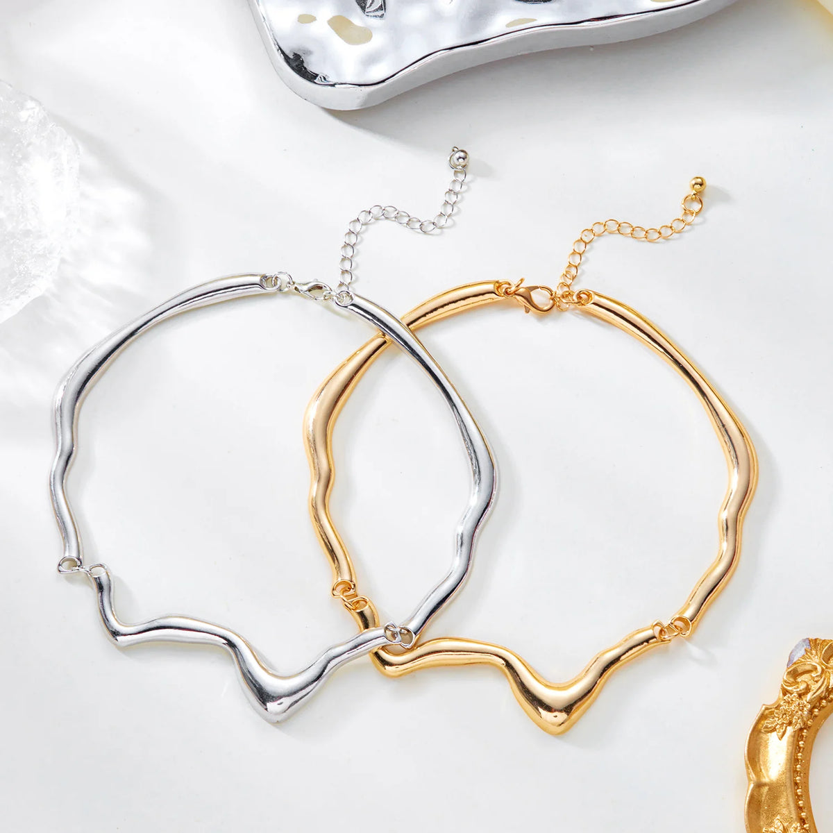 Gold and silver openwork bracelets on a white surface