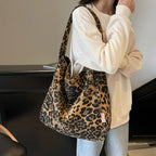Person holding a leopard print bag indoors