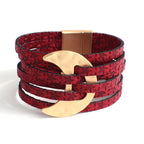 Red textured bracelet with a gold crescent moon charm on a white background