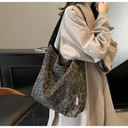 Person holding a leopard print bag in an indoor setting
