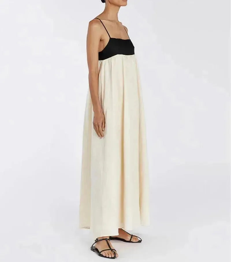 Person wearing a black top and long white skirt on a plain background