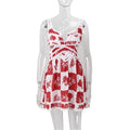 A woman wearing a red and white floral mini dress with a V-neck and sleeveless design, standing on a staircase.