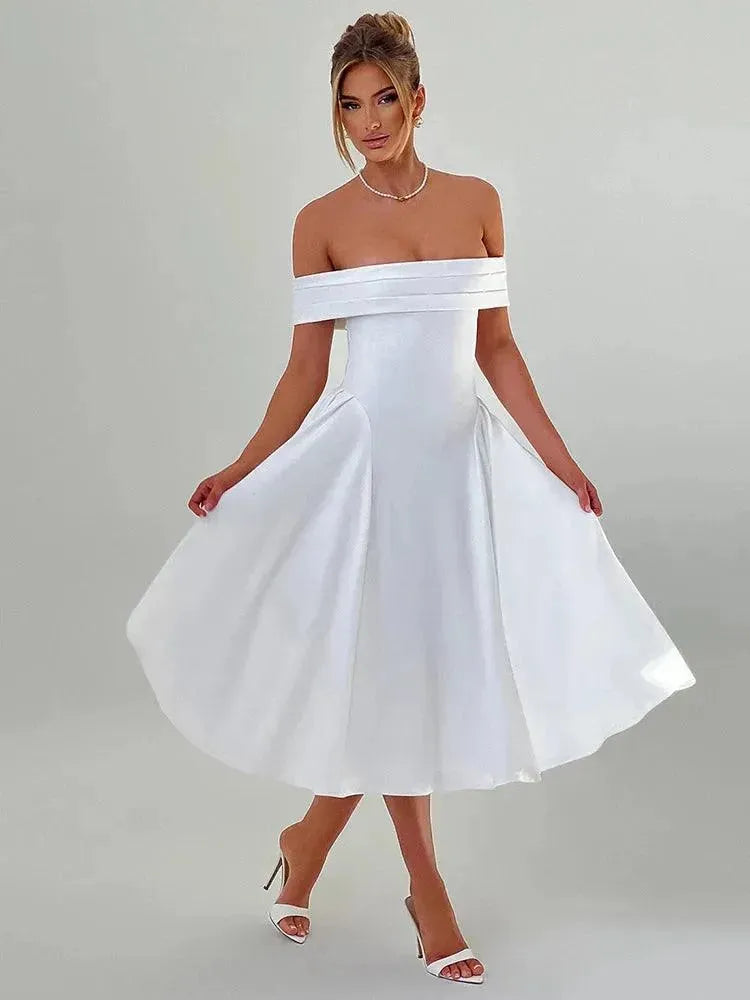 Woman wearing a white off-shoulder dress against a plain background