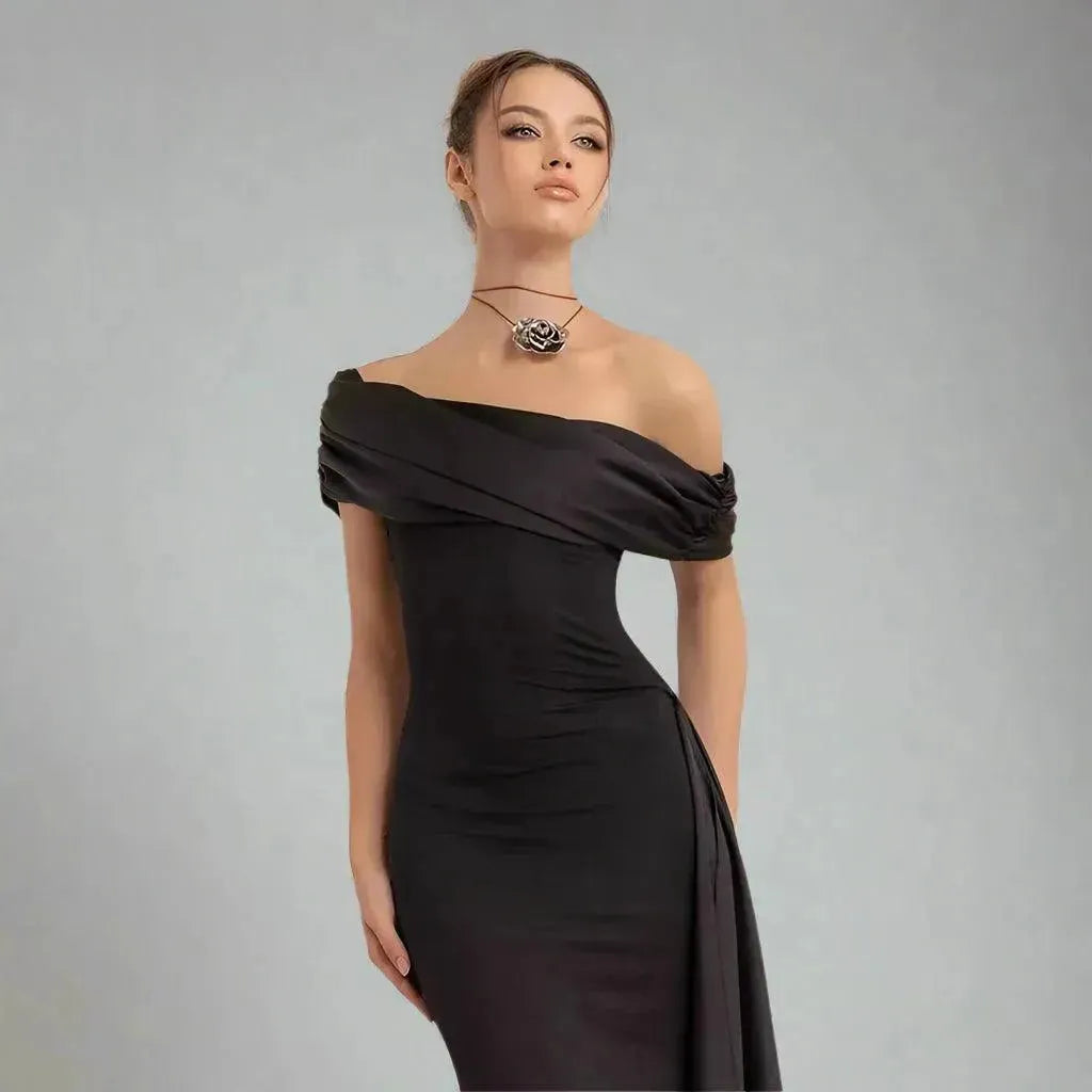 Woman wearing a black off-shoulder dress against a gray background