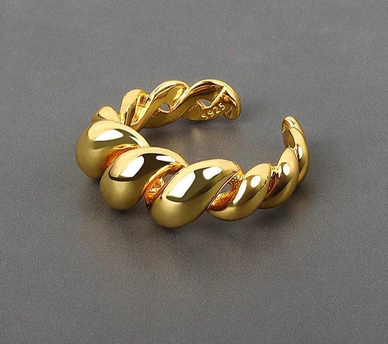 A sterling silver vintage-style twist ring with a gold/silver color.