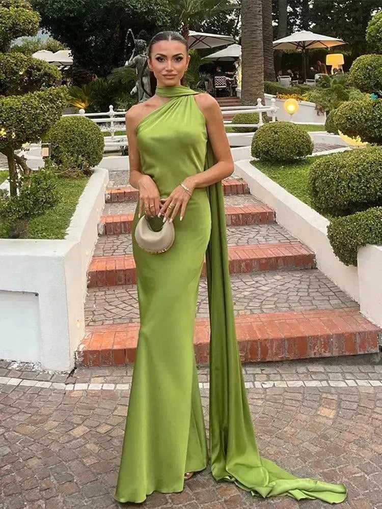 Woman in a green dress standing on a garden staircase.