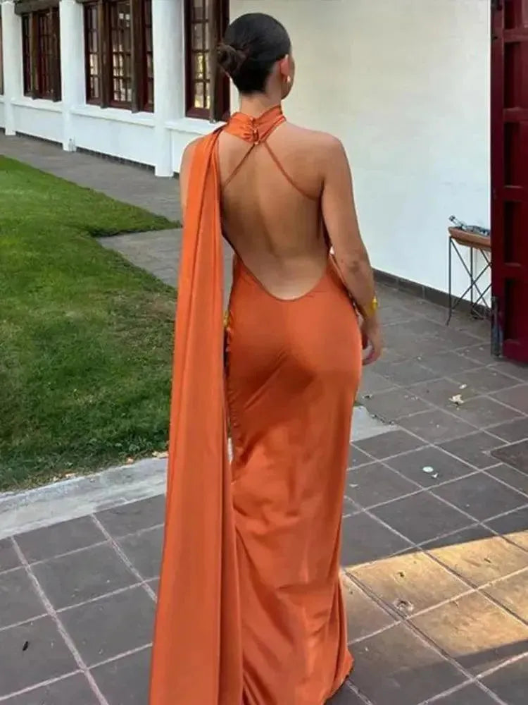 Person wearing an orange dress with a high slit outdoors.