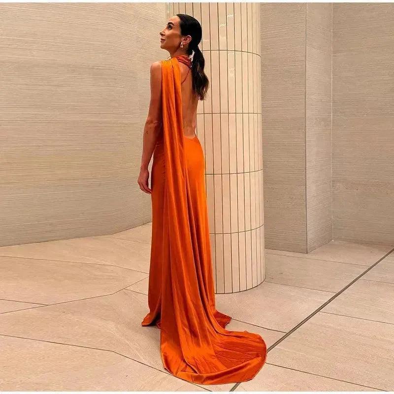 Woman in an orange evening gown in a modern room.