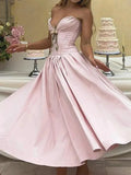 Pink strapless dress with a cake in the background