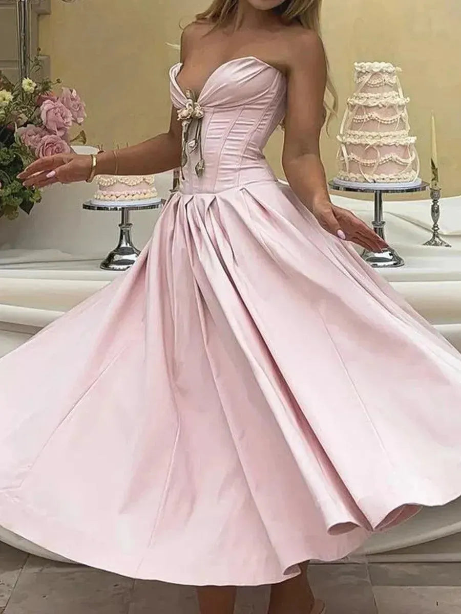 Pink strapless dress with a cake in the background