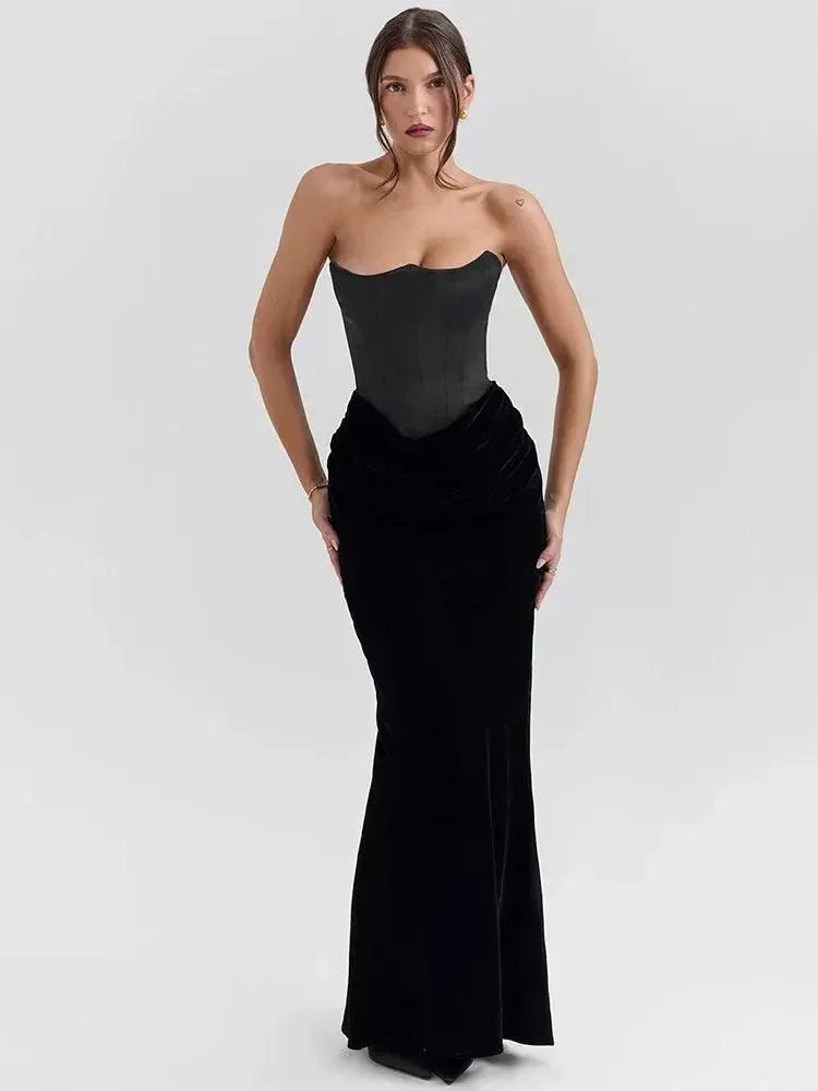 A model wearing a black strapless maxi dress with a sweetheart neckline and ankle-length skirt.