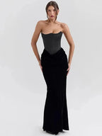 A model wearing a black strapless maxi dress with a sweetheart neckline and ankle-length skirt.