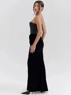 Model wearing a black strapless gown on a white background.