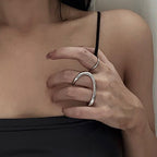 A person wearing a silver-colored ring on their finger, with the rest of their hand and the ring's band visible.