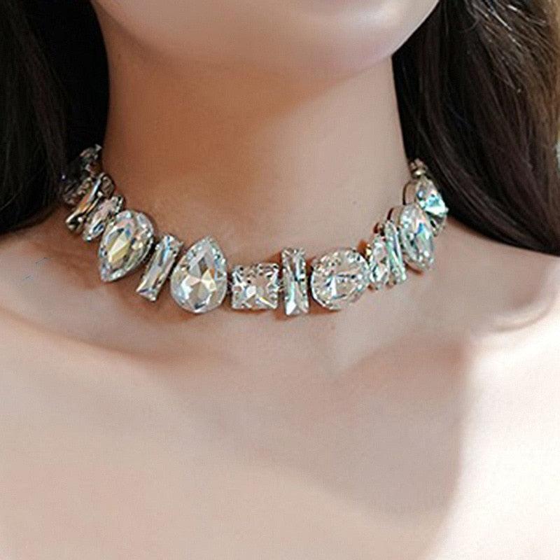 A mannequin wearing a silver-colored choker necklace with multiple round and square crystal pendants.